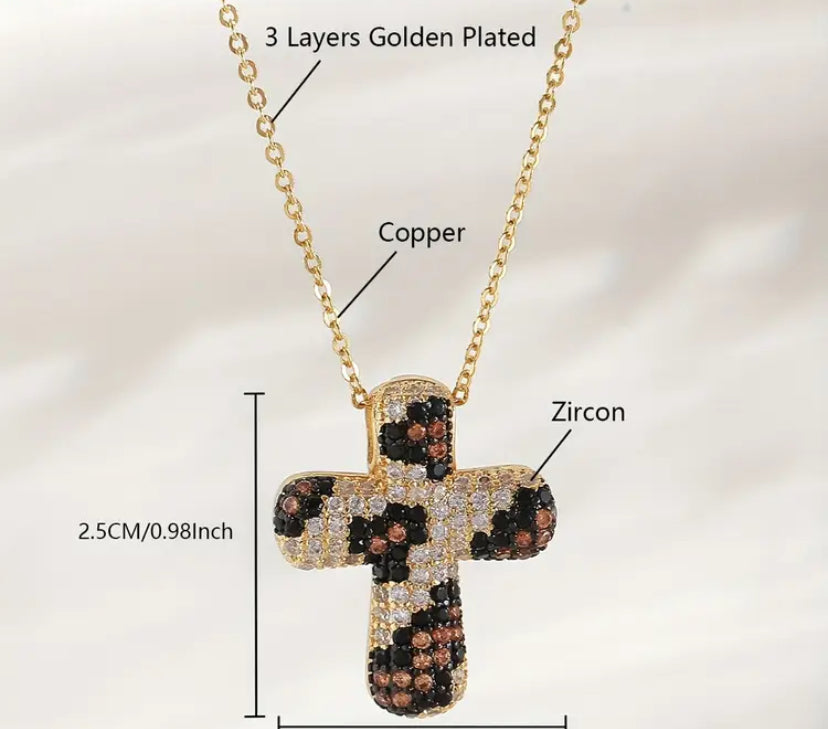 Gold cross pendant with zircon stones on a chain, labeled for material composition.