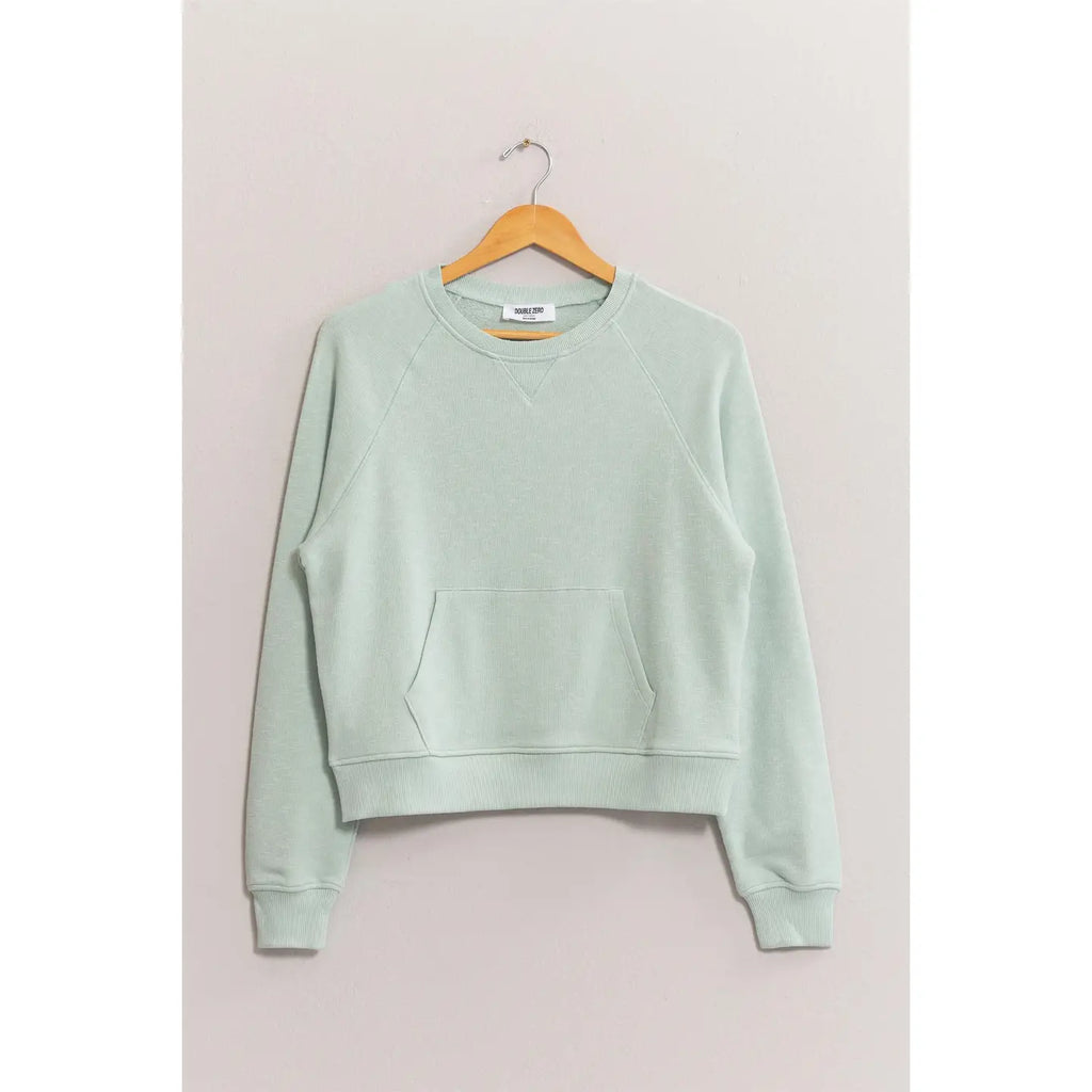 Light green sweatshirt on a wooden hanger against a plain background